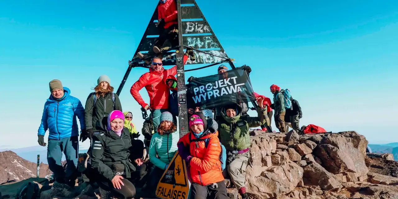 Grupa zdobywców na szczycie Jabal Toubkal, z flagą "PROJEKT WYPRAWA.PL".