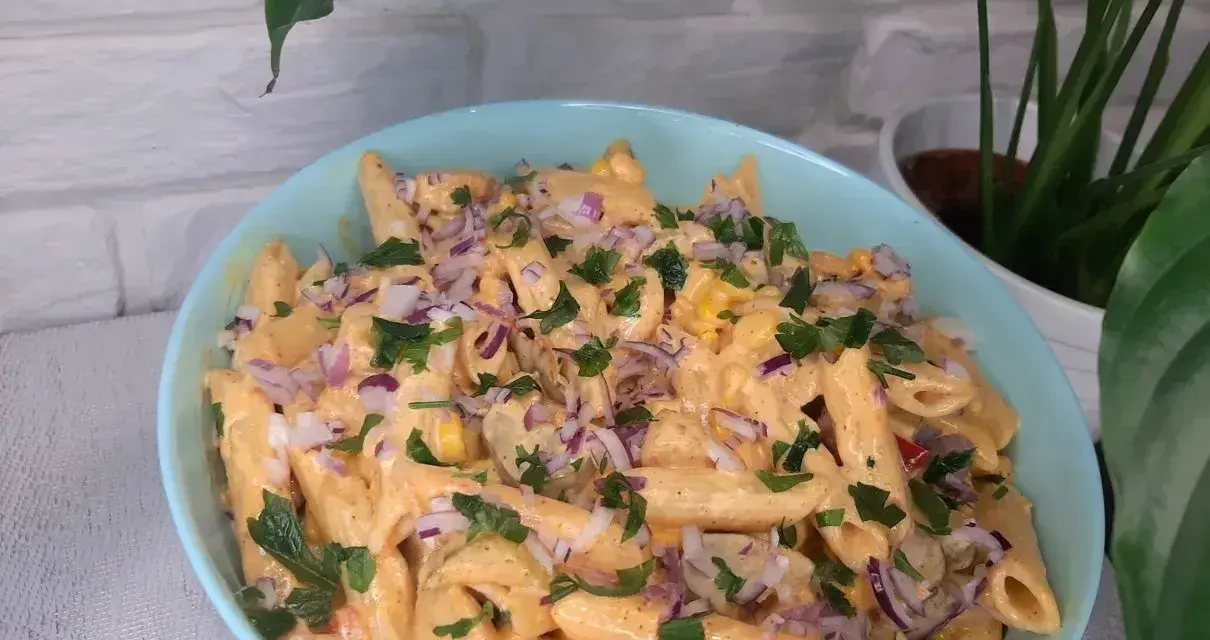Penne z sosem gyros, kukurydzą i czerwoną cebulą, posypane natką pietruszki. Pyszna sałatka gyros z makaronem.