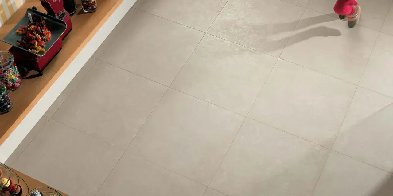 Un enfant court sur un sol carrelé 60x60. L'épaisseur du joint du carrelage est subtile, soulignant la modernité de la pose.
