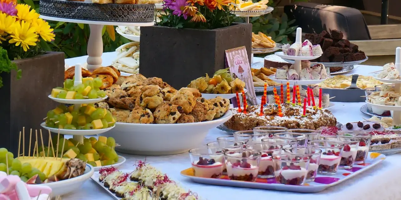 Vielfältige Brunch Ideen: Croissants, Scones, Obstspieße, Brownies und süße Desserts in Gläsern laden zum Genießen ein.