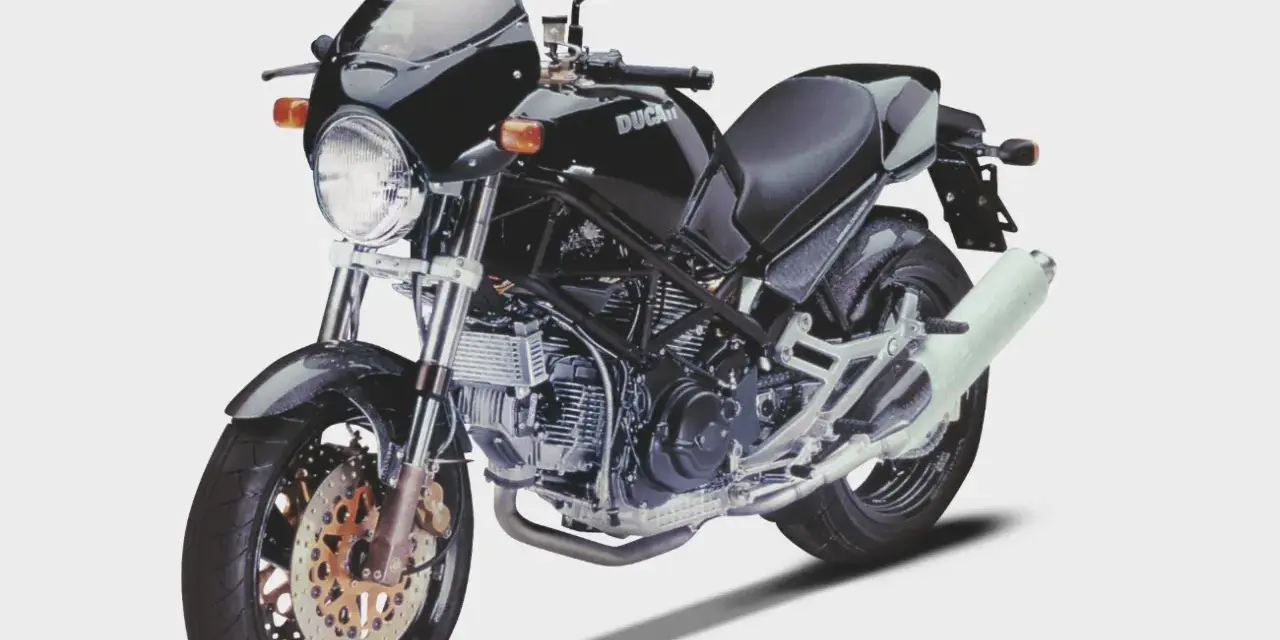 Czarny Ducati Monster z owiewką i sportowym wydechem. Klasyka motoryzacji, która wciąż budzi emocje.