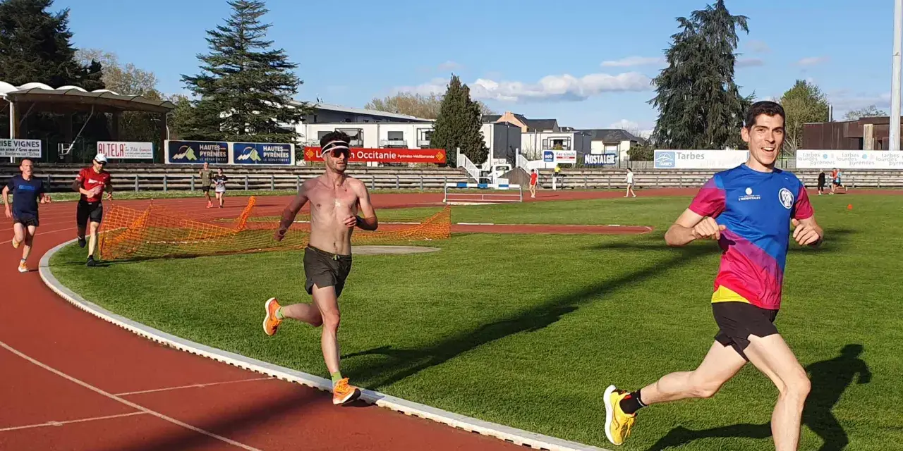 Coureurs sur piste, s'entraînant pour savoir combien de jours de repos avant une compétition. Le soleil brille sur la piste d'athlétisme.