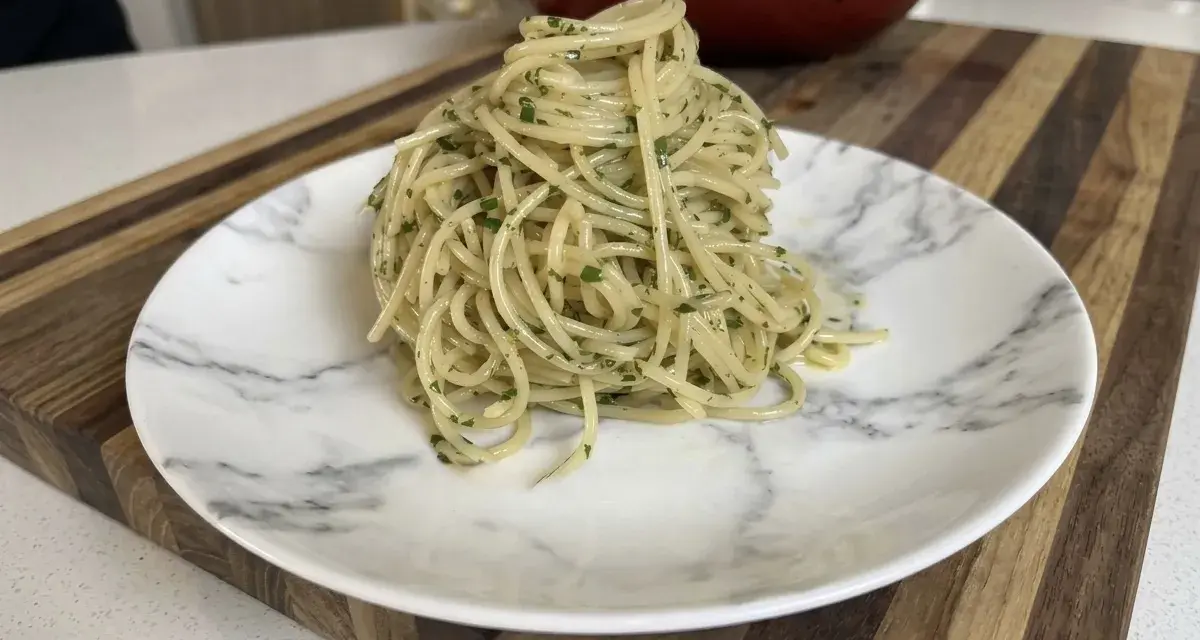 Un plato de spaghetti aglio e olio, con perejil picado, listo para disfrutar.