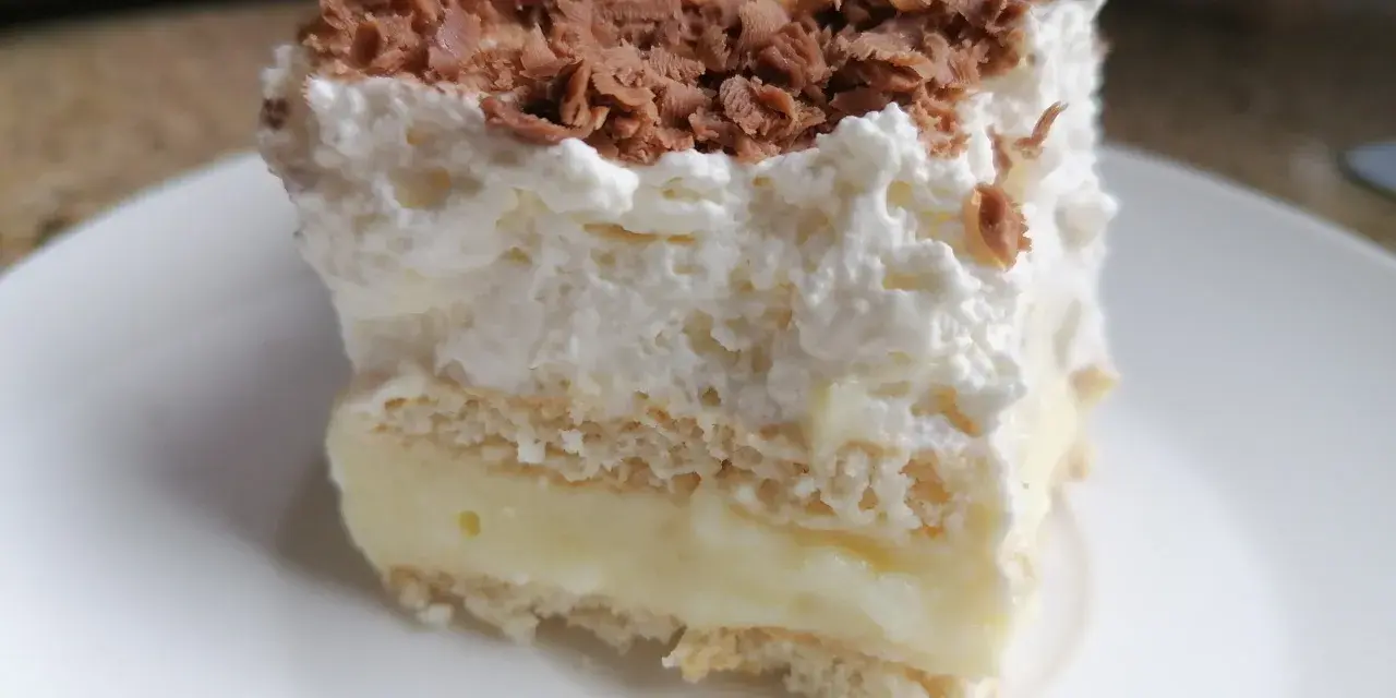 Szybkie ciasto z budyniem i bitą śmietaną, posypane wiórkami czekolady. Idealne na deser!