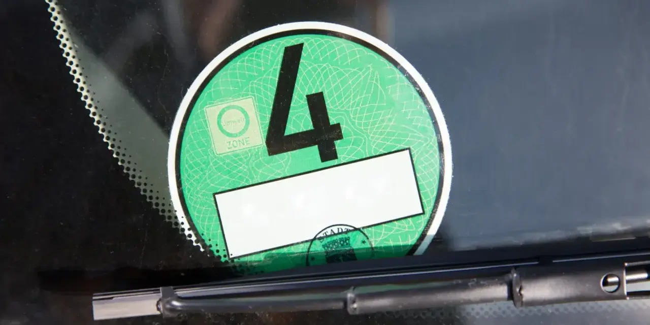 Grüne Umweltplakette mit der Nummer 4. Diese zeigt, welche Schadstoffklasse ist gut für die Umweltzone.