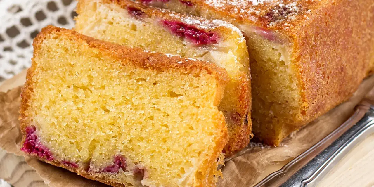 Puszyste ciasto z serka wiejskiego z malinami, posypane cukrem pudrem. Idealne na podwieczorek.