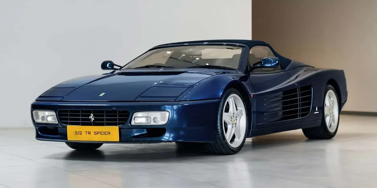Niebieskie Ferrari 512 TR Spider z lat 90. błyszczy na wystawie, gotowe na przejażdżkę.