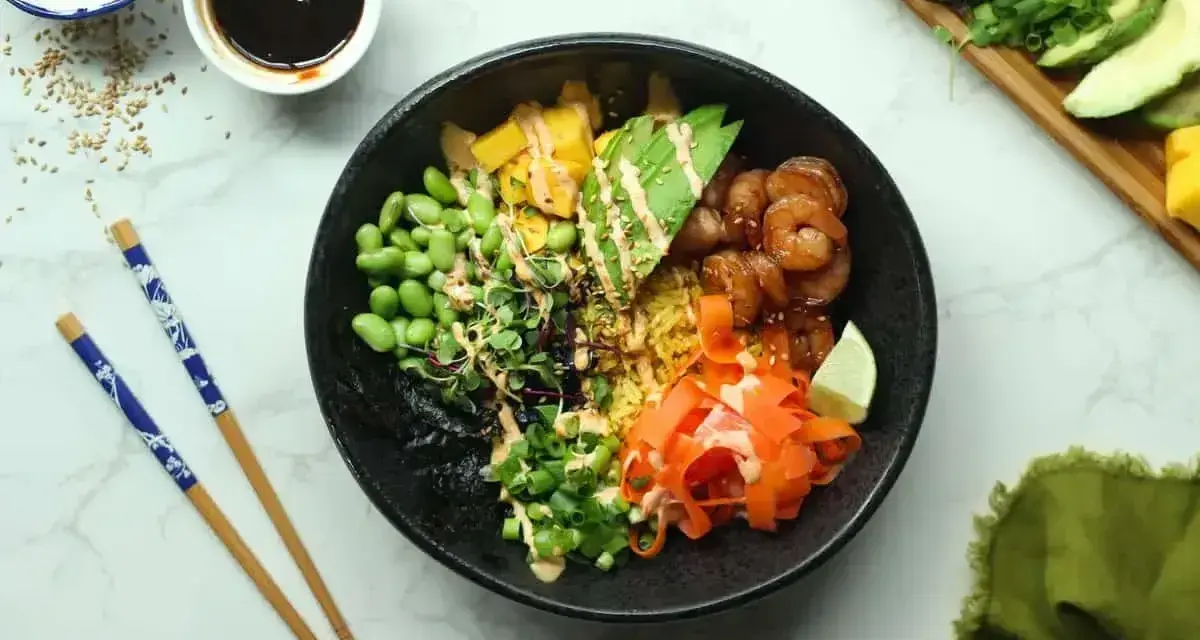 Kolorowy poke bowl z krewetkami, awokado, edamame i marchewką. Idealny przepis na szybki i zdrowy posiłek.