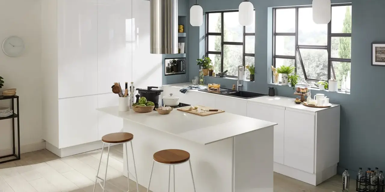 Cuisine moderne aux murs bleu ardoise. Une cuisine d'inspiration pour savoir comment faire de la peinture, avec îlot central, tabourets et vue sur jardin.