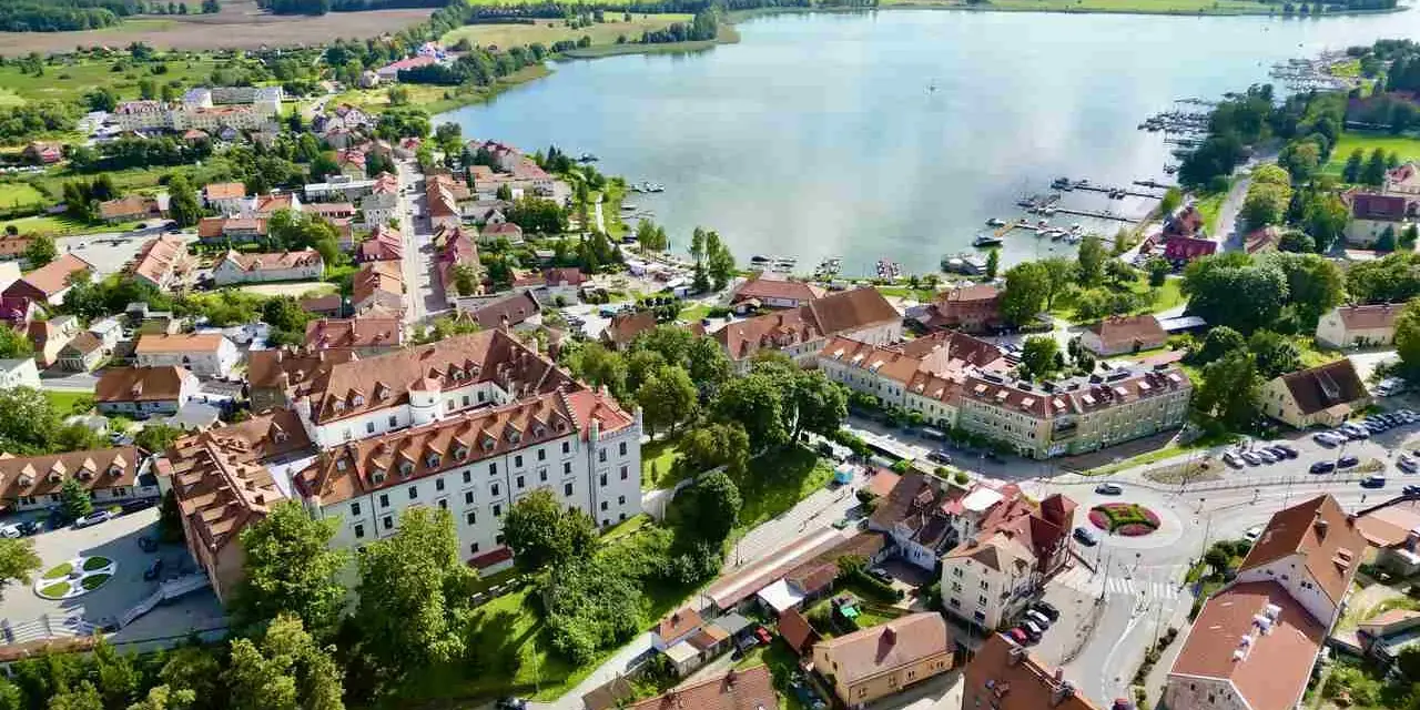 Widok z lotu ptaka na miasteczko nad jeziorem, z zamkiem i mariną. Idealne miejsce, gdzie na Mazury.