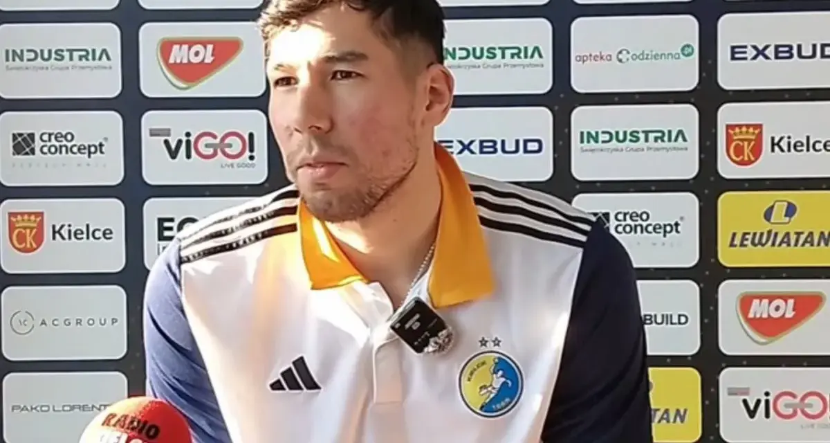 Daniel Dujshebaev w koszulce z herbem klubu, przed ścianką sponsorską z logo "Industria Kielce".