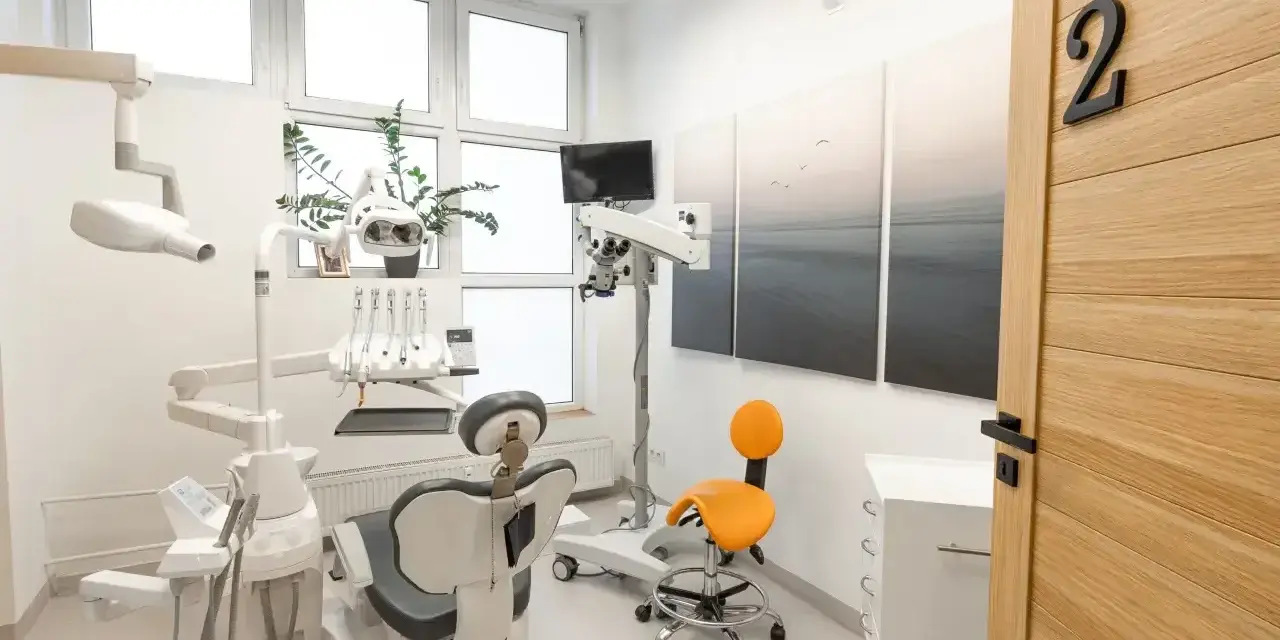 Nowoczesny gabinet stomatologiczny z fotelem, mikroskopem i drzwiami z numerem 2.