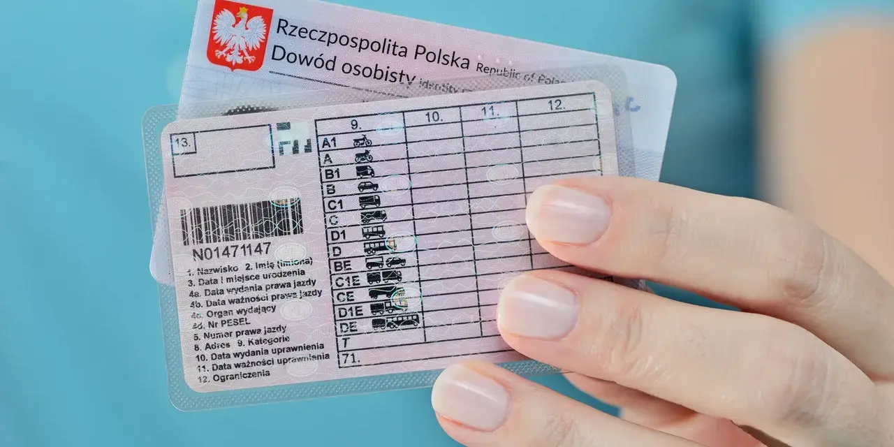 Polskie prawo jazdy z kategoriami, w tym kat. B, w dłoni. Dokumenty do prowadzenia pojazdów.