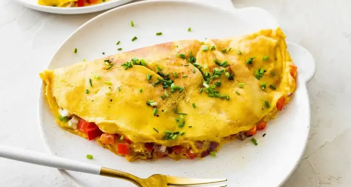 Złocisty omlet z białek, nadziany warzywami i serem, posypany szczypiorkiem. Idealny na lekki posiłek.