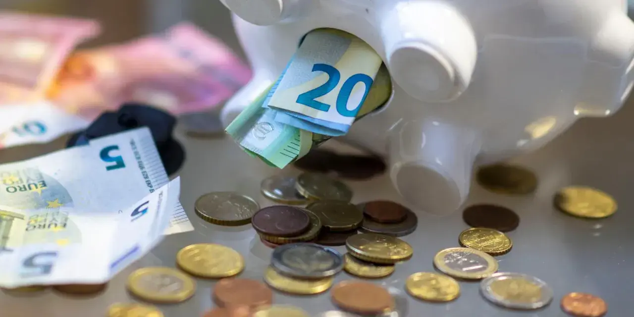Sparschwein mit Euro-Scheinen und Münzen. Vielleicht reicht es bald für free now taxi preise.