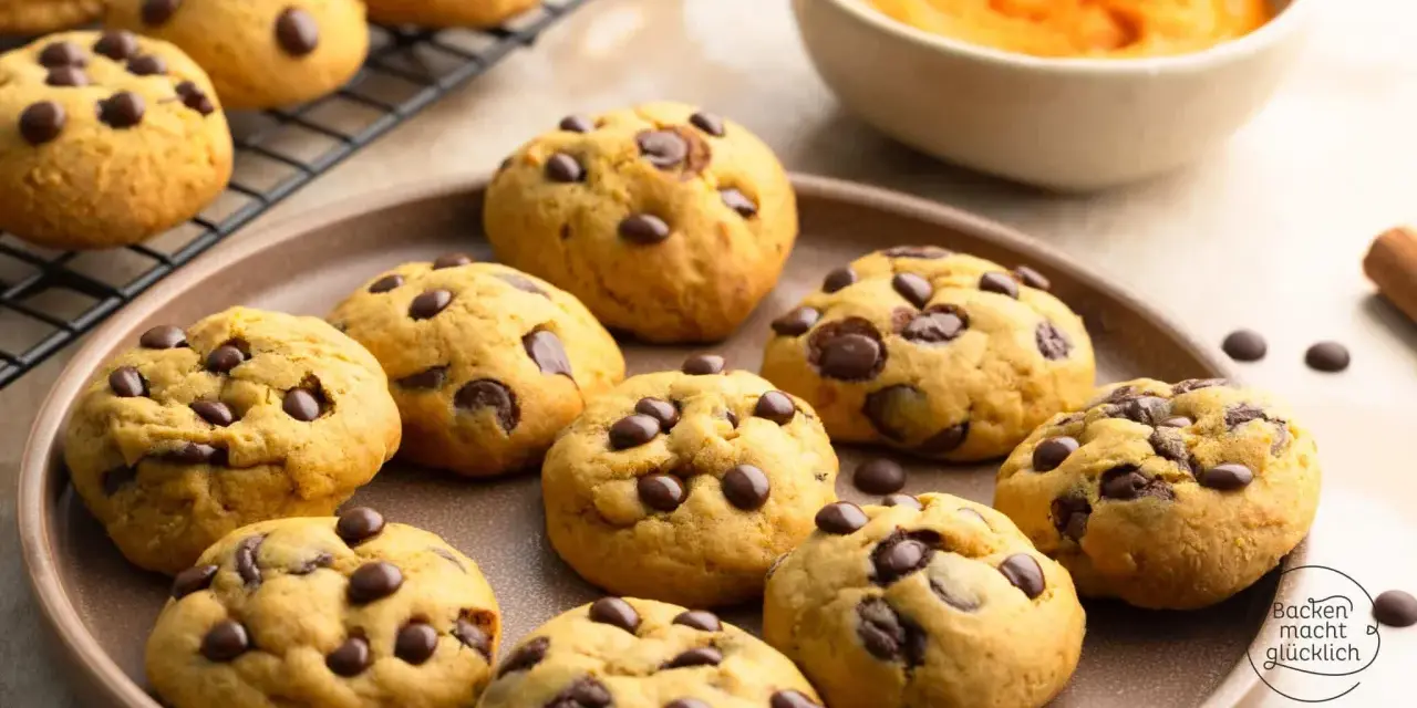 Saftige Schoko-Cookies, perfekt für jedes Cookies Rezept. Auf einem Teller und Gitterrost arrangiert, mit einer Schüssel Kürbispüree im Hintergrund.