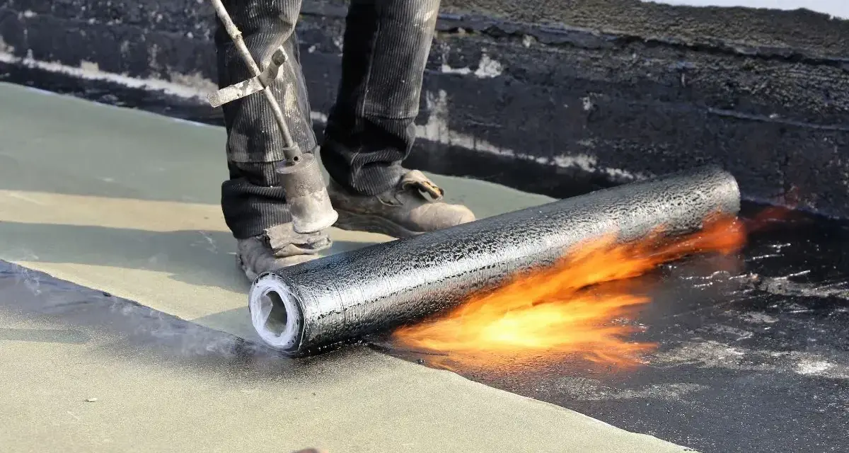 Pose d'une membrane bitumineuse sur une terrasse. Le prix de l'étanchéité d'une terrasse carrelée dépend de la technique utilisée.