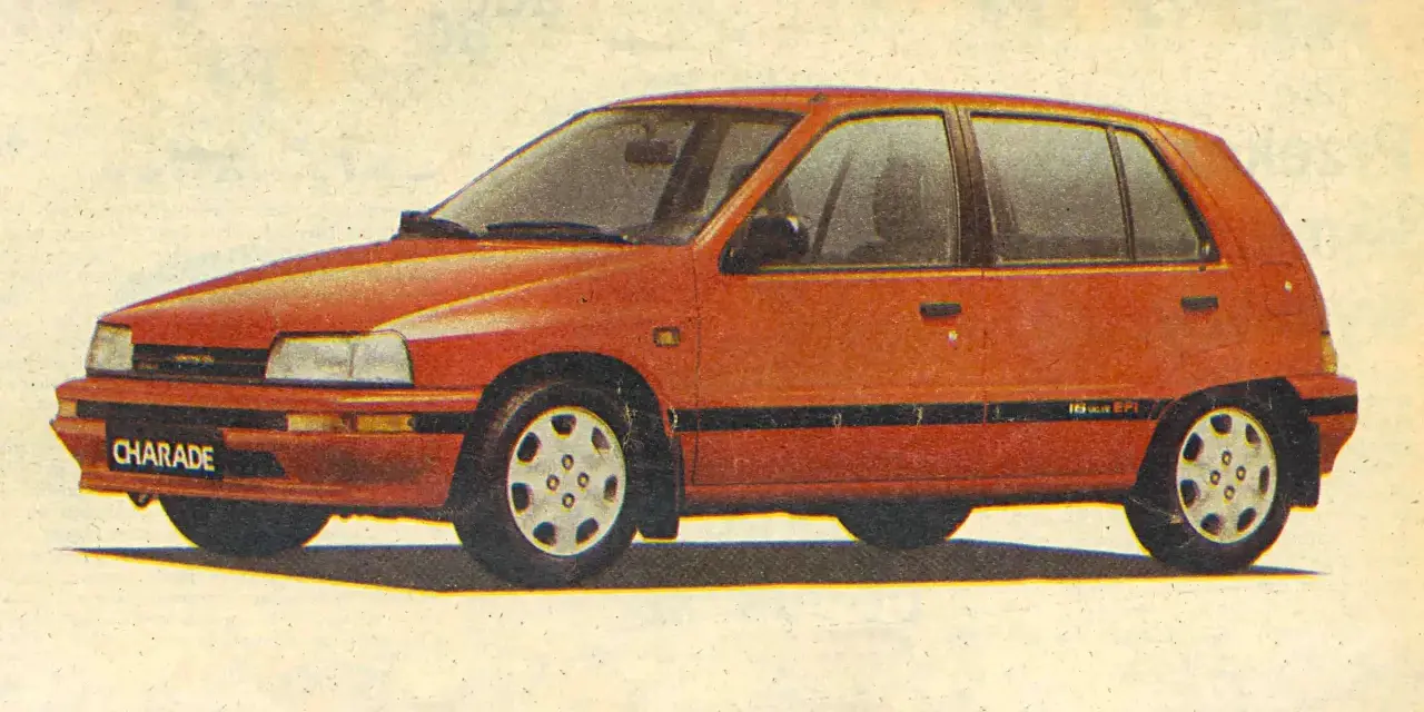 Czerwony Daihatsu Charade z lat 90. na tle jasnego, lekko zszarzałego papieru.