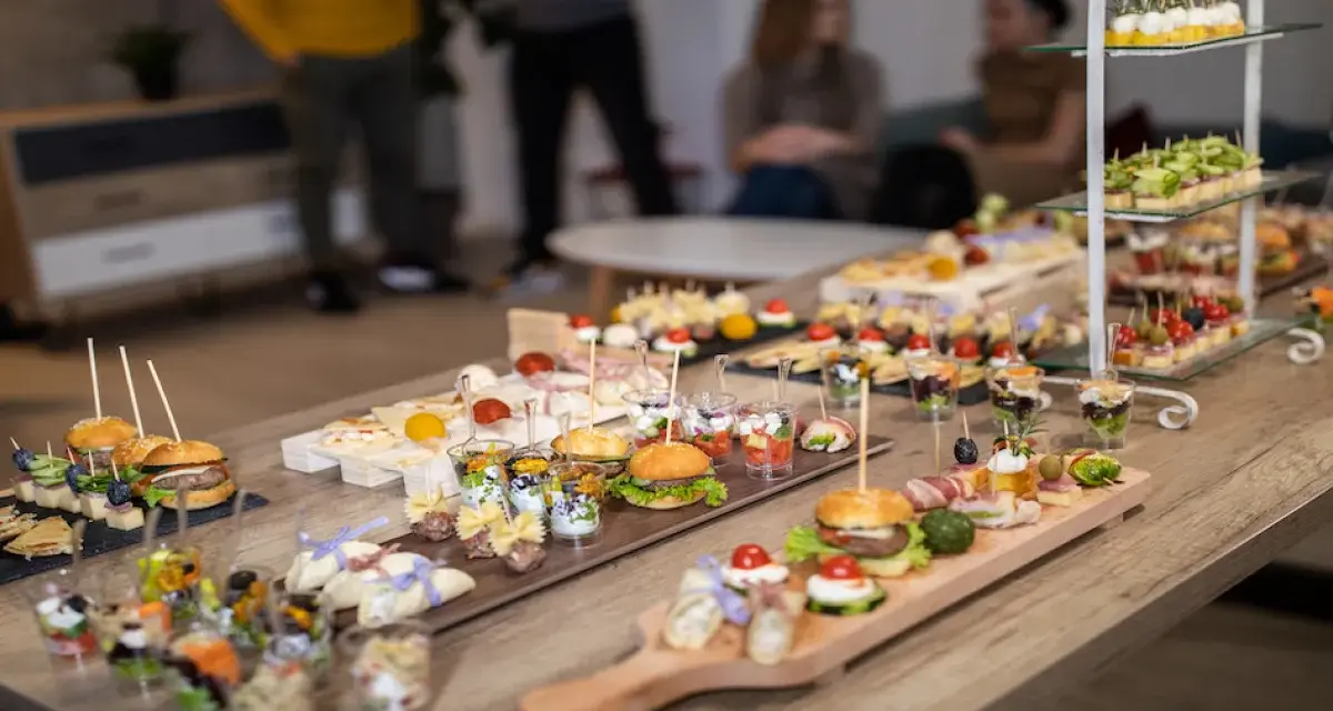 Stół pełen pysznych finger food: mini burgery, koreczki, przekąski w pucharkach. Idealne na imprezę!