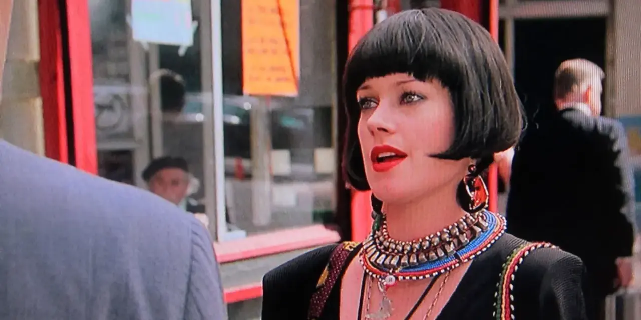 Melanie Griffith in un film, con un taglio di capelli a caschetto e un look audace.