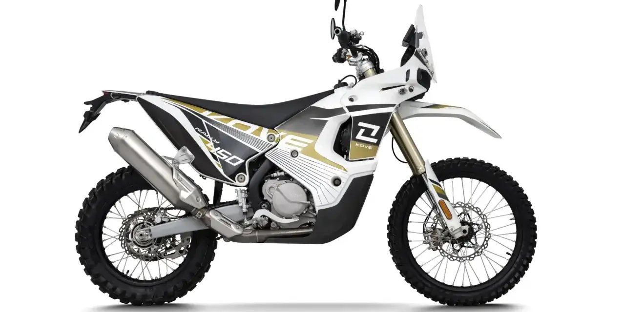 Biało-złoty motocykl Kove 450 Rally z owiewką i oponami terenowymi.