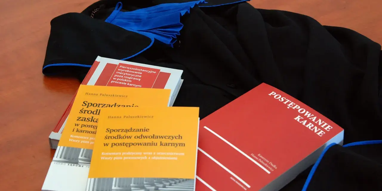 Książki o prawie karnym i togi prawnicze. Wiedza o prawach przysługujących oskarżonemu w sądzie jest kluczowa.