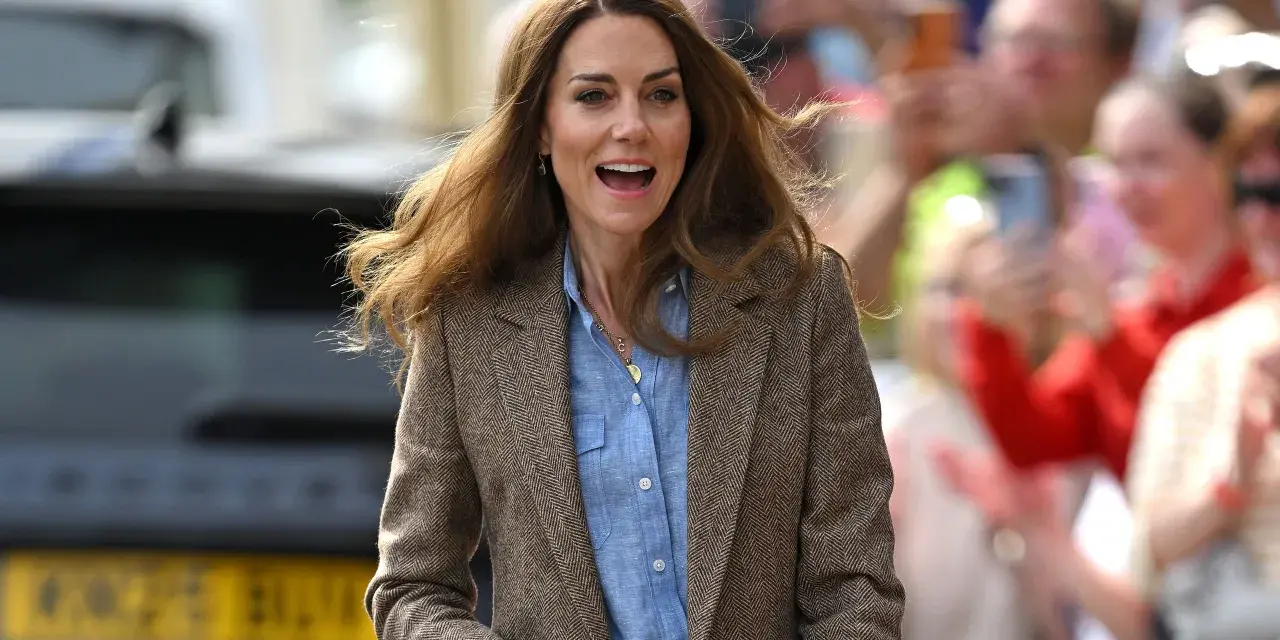 La principessa Kate sorride entusiasta tra la folla, con i capelli mossi dal vento. Le ultime notizie la vedono impegnata in un evento pubblico.