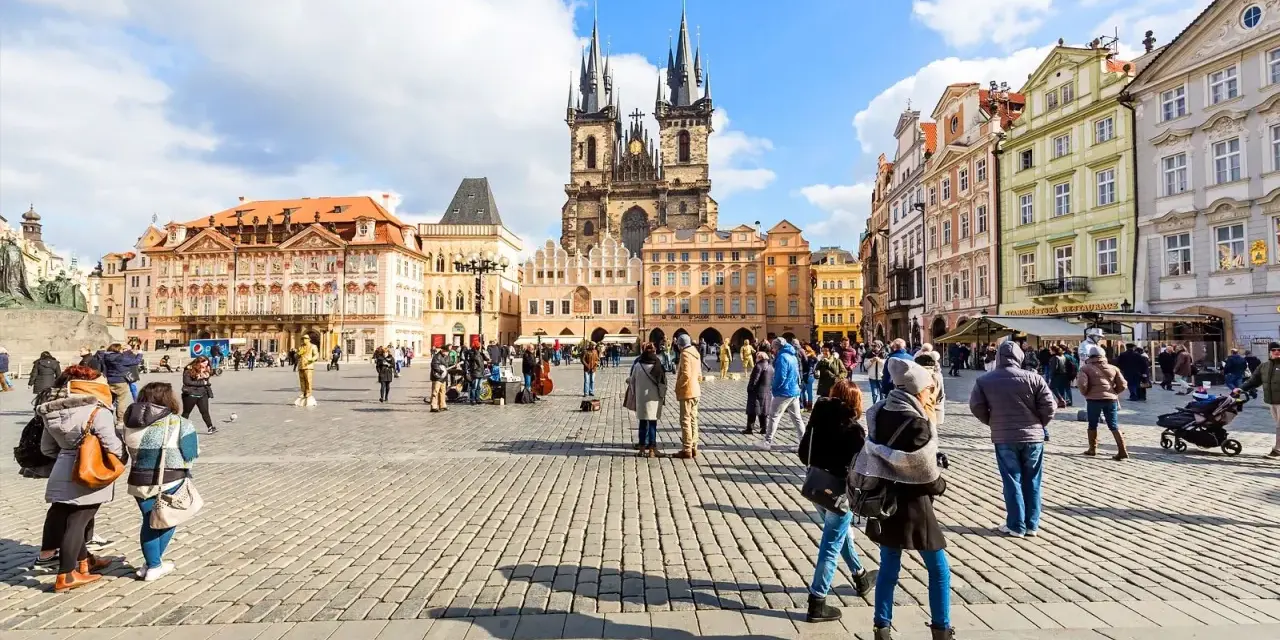 People enjoy Prague tours in Old Town Square, with the Church of Our Lady before Týn dominating the skyline.