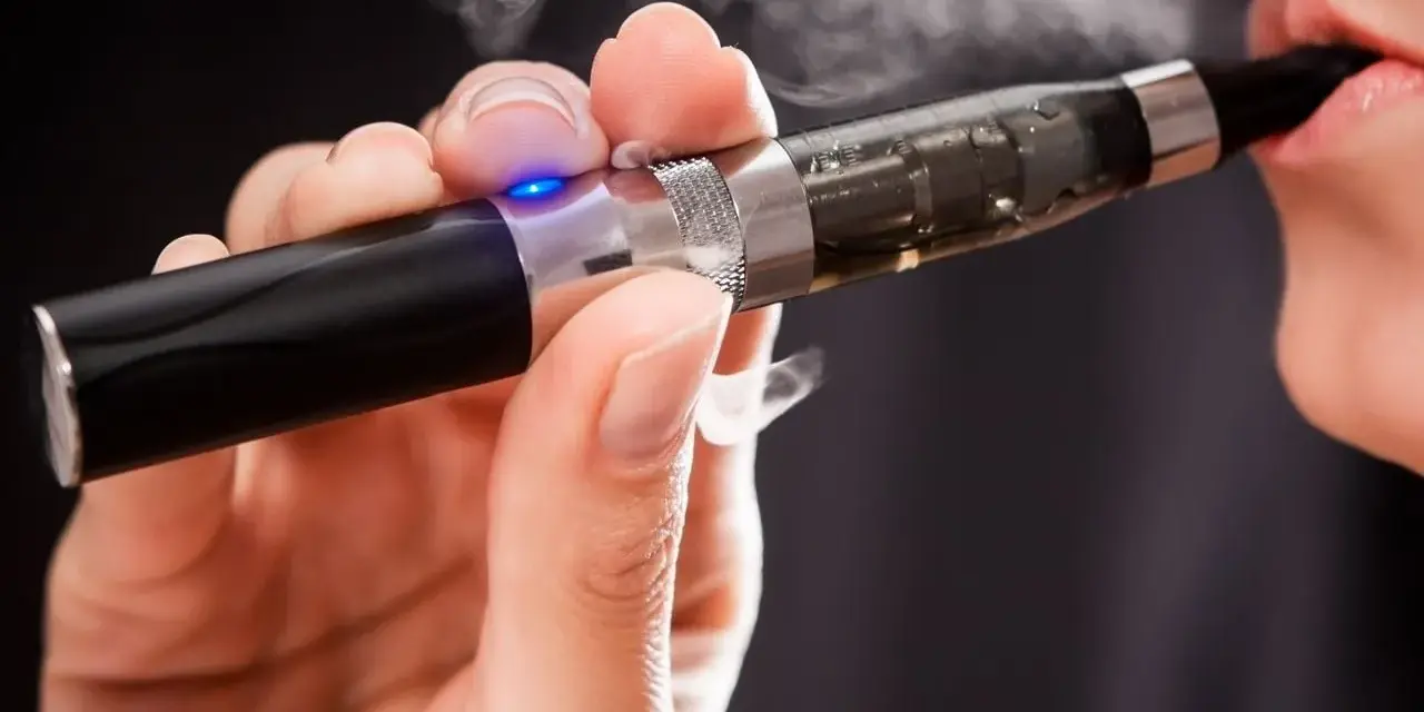 Persona usa un vaper saludable, exhalando vapor blanco.