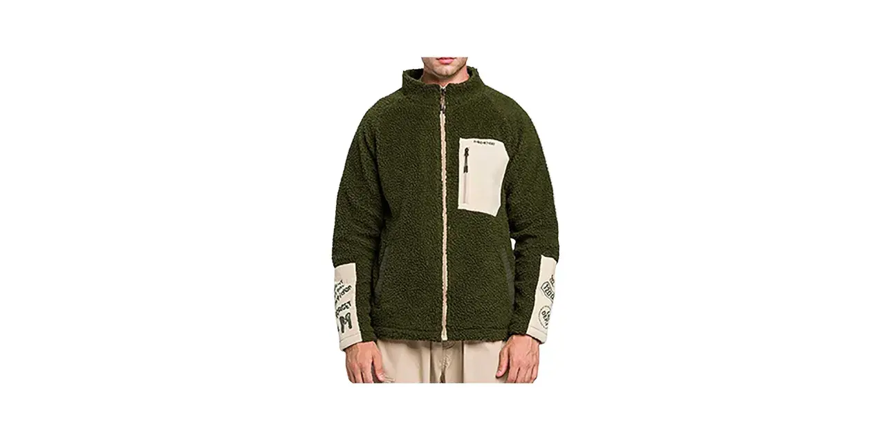 Giacca sherpa verde Stüssy con tasca beige e dettagli grafici sulle maniche. Perfetta per un look urbano e casual.