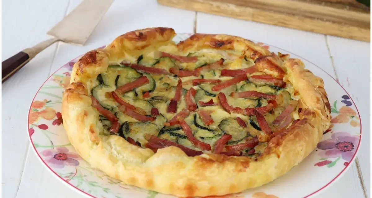 Torta salata con zucchine e speck, dorata e invitante, pronta per essere gustata.