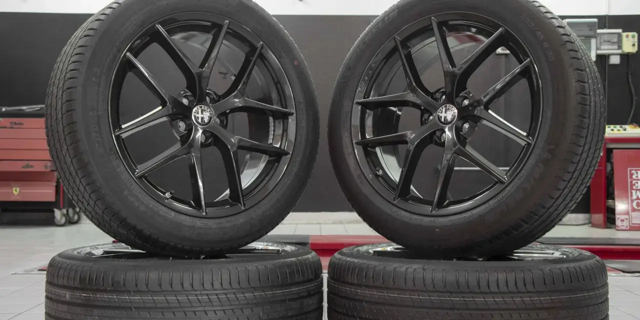 Cerchi in lega neri lucidi con logo Alfa Romeo, perfetti per un'Alfa Romeo Stelvio. Gomme Michelin Latitude Sport 3.