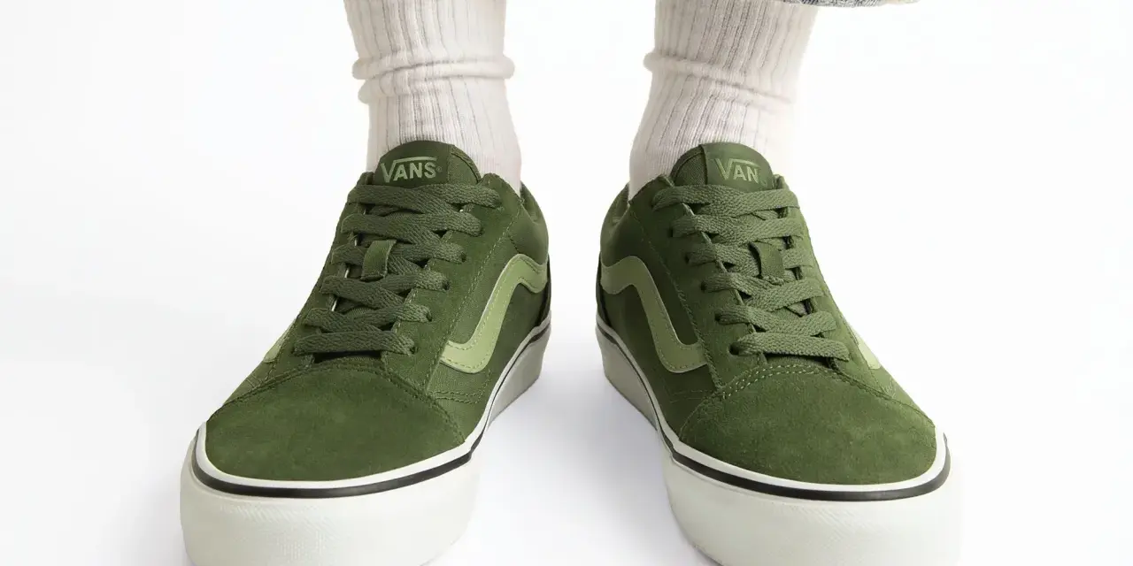 Zielone trampki Vans z jasną falą. Czy to rozmiar buta 11.5 cm? Białe skarpetki i podarte jeansy dopełniają stylizację.