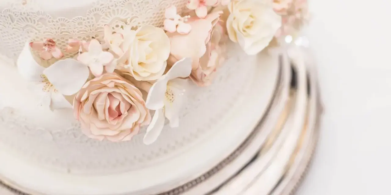 Elegancki tort weselny z różami i koronką. Sprawdź, jaka jest tort weselny cena, by zaplanować idealne przyjęcie.