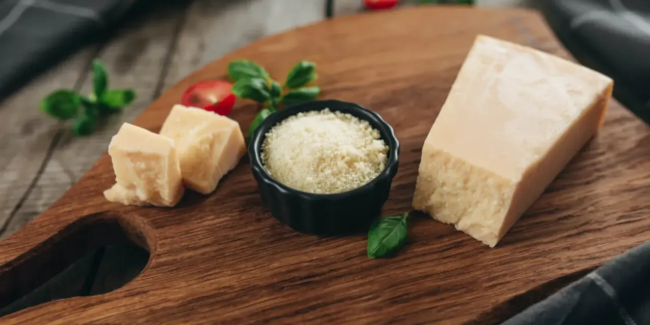 Kawałek parmezanu i starty ser w miseczce, idealne do carbonary, gdy szukasz alternatywy dla parmezanu.
