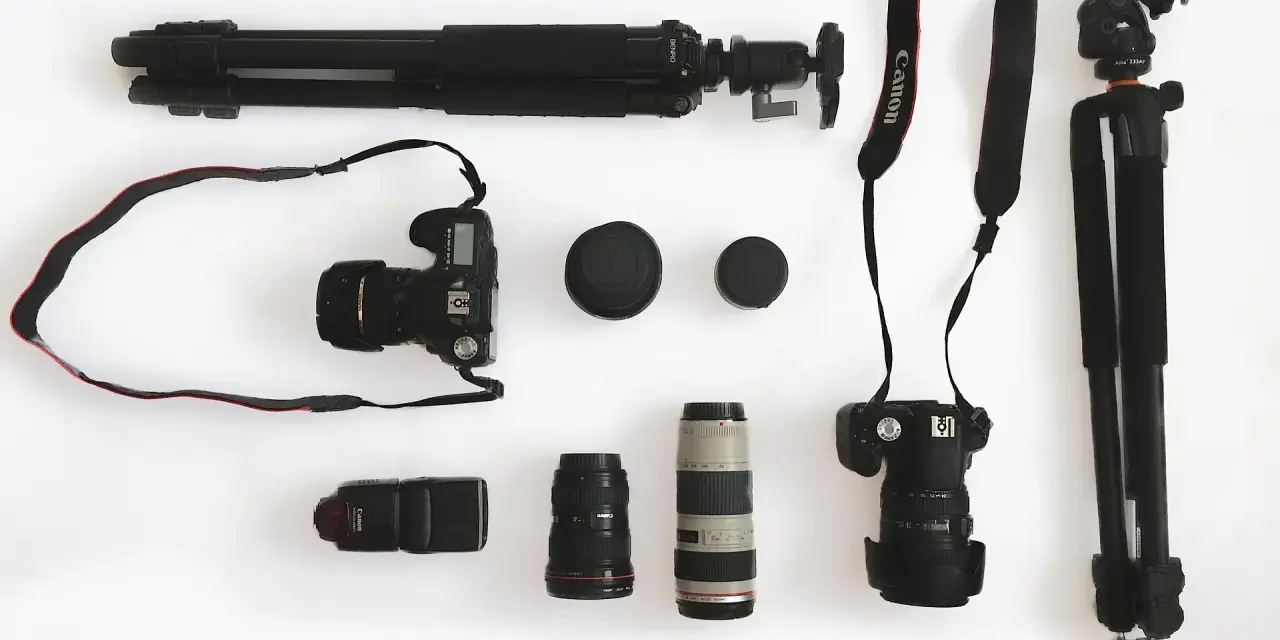 Ensemble d'un appareil photo reflex, d'objectifs, d'un flash et de trépieds, prêt pour une séance photo.