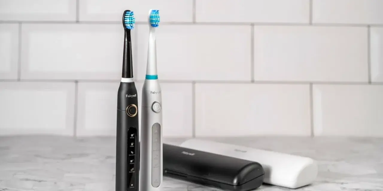 Dwa eleganckie modele szczoteczek sonicznych, czarny i srebrny, z różnymi końcówkami do wyboru. Obok etui podróżne.