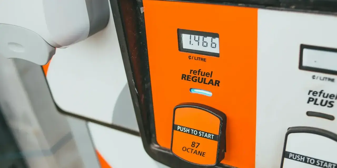 Zbliżenie na dystrybutor paliwa z wyświetlaczem ceny i przyciskiem "Push to Start".