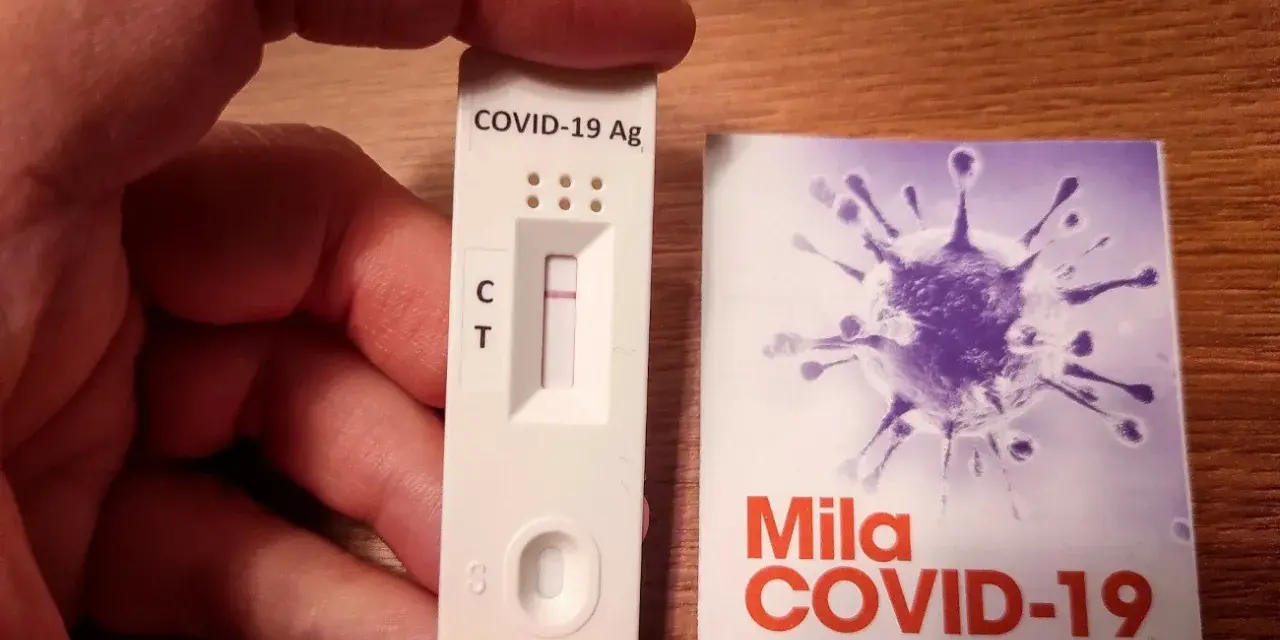 Szybki test antygenowy COVID-19 z jedną kreską kontrolną. Obok opakowanie z grafiką wirusa.
