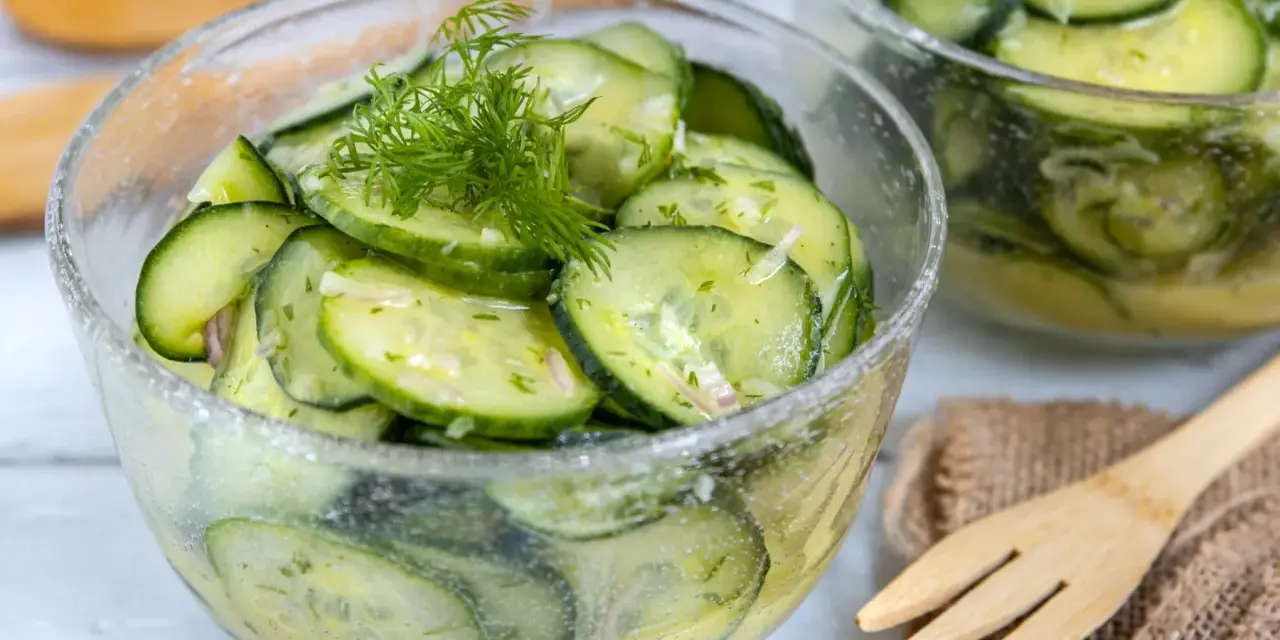 Frischer Gurkensalat mit Dill und Zwiebeln, ein einfaches Gurkensalat Rezept, serviert in einer Glasschüssel.