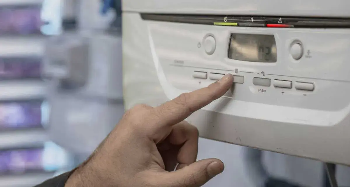 Mano presionando un botón en la caldera de gas, indicando posibles problemas. La pantalla muestra "02".