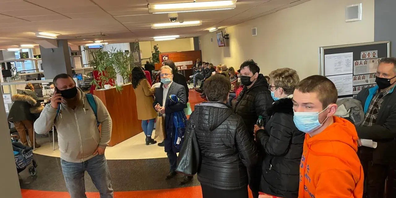 Kolejka ludzi w biurze paszportowym w Częstochowie. Niektórzy mają maseczki.