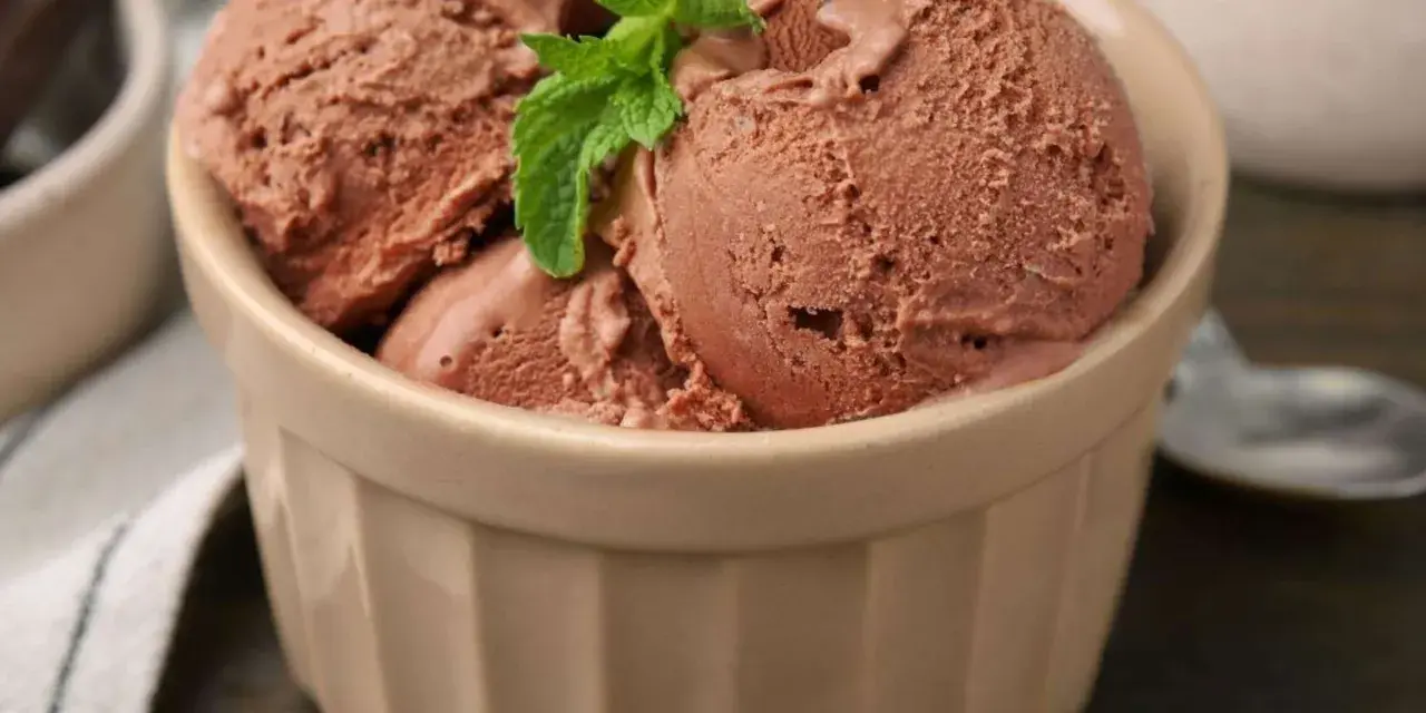 Schokoladeneis-Kugeln in einer Schale, garniert mit Minze. Perfekt, wenn du **eisbasis selber machen** möchtest.