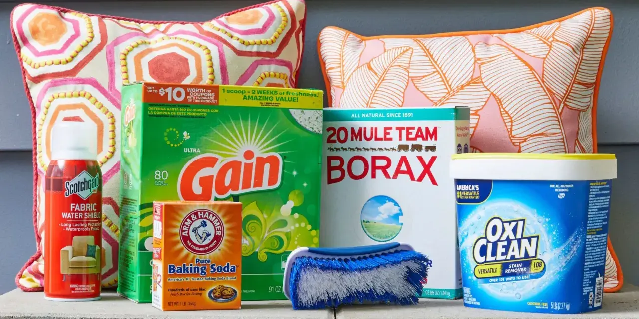 Supplies for how to clean outdoor cushions: Scotchgard, Gain detergent, Borax, baking soda, OxiClean, and a scrub brush.