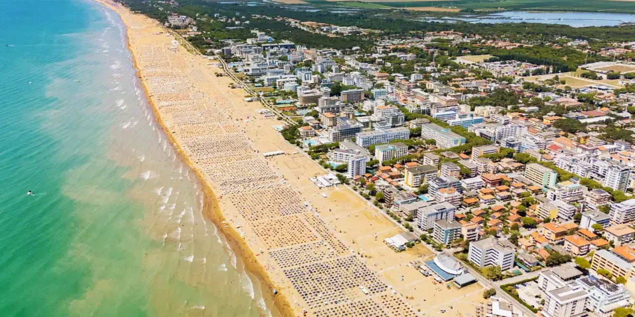 Słoneczna bibione plaża tętni życiem. Tysiące leżaków i parasoli tworzy barwny dywan, a turkusowe morze zaprasza do kąpieli.