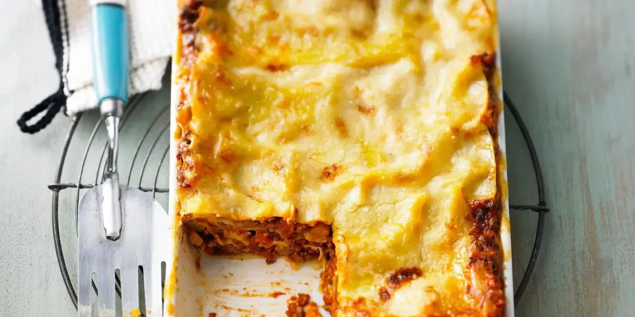 Eine frisch gebackene, goldbraune Lasagne mit geschmolzenem Käse, die Lust auf diese perfekte Lasagne macht.