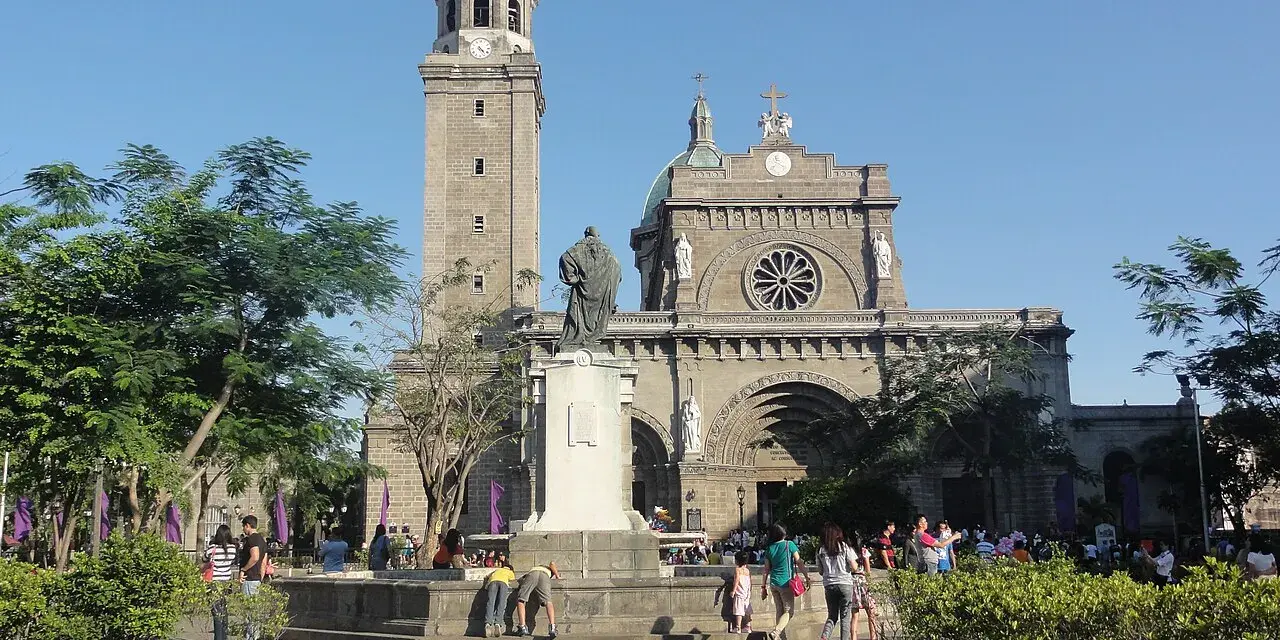 Manila Cathedral, symbol Filipiń religia. Ludzie spacerują przed monumentalną budowlą, podziwiając architekturę i atmosferę.