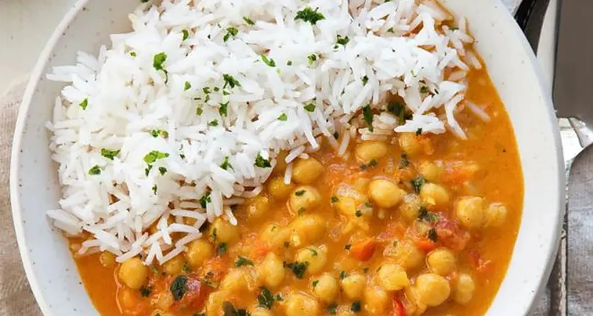 Un delicioso curry de garbanzos con arroz blanco esponjoso, espolvoreado con perejil fresco.