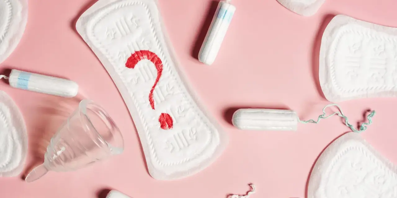 Brązowe plamienie zamiast okresu? Podpaski, tampony i kubeczek menstruacyjny na różowym tle symbolizują niepewność.