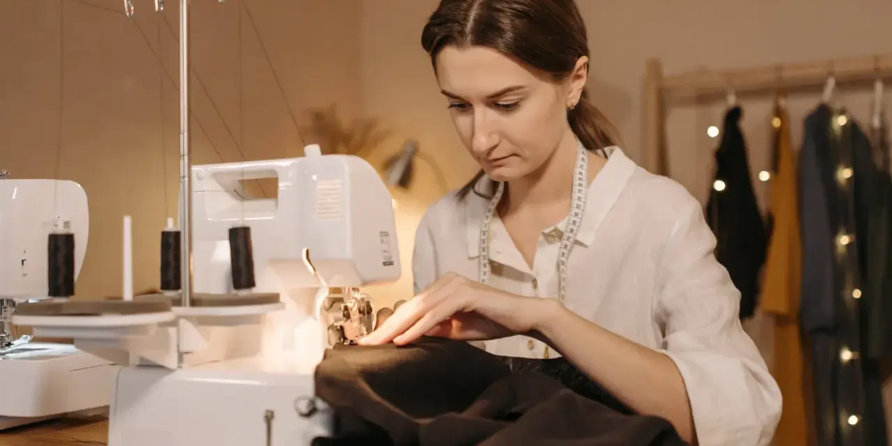 Une couturière utilise une surjeteuse pour créer un patron housse de chaise Burda.